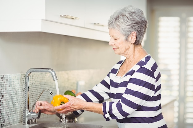 Senior Frau waschen Paprika