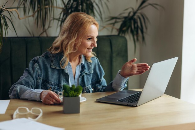 Senior Geschäftsfrau sitzt im Café und arbeitet am Laptop Reife Frau im Café mit Laptop-Computer