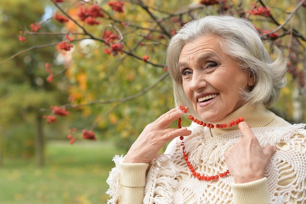 Senior hermosa mujer con encaje de bayas posando al aire libre