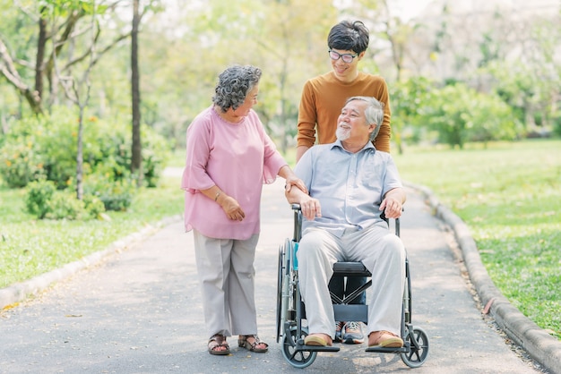 Senior hombre asiático en silla de ruedas con su esposa e hijo