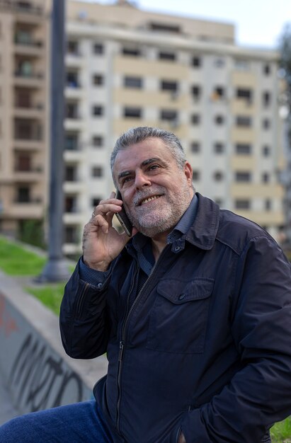 Senior hombre con barba caminando en la ciudad