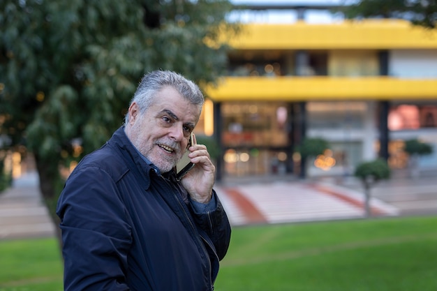 Senior hombre con barba caminando en la ciudad