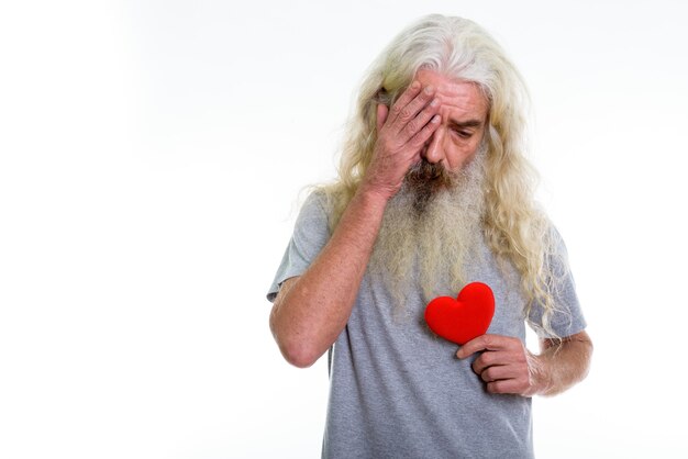 Senior hombre barbudo con cara de tristeza mientras sostiene rosa roja