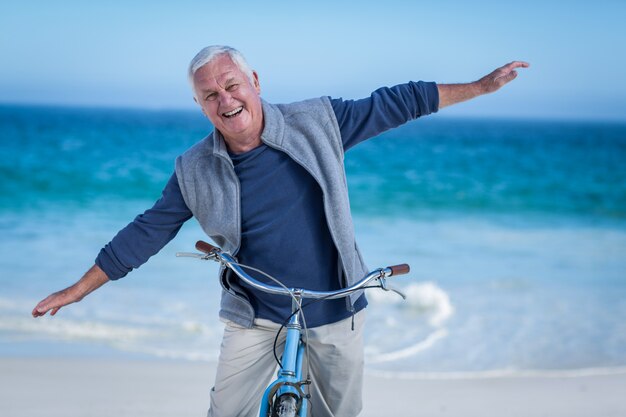 Senior hombre con una bicicleta extendiendo los brazos