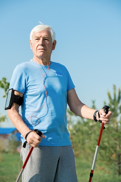 Foto senior hombre caminando con bastones