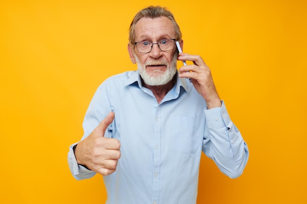 Senior hombre canoso barba gris con gafas hablando por teléfono de fondo aislado