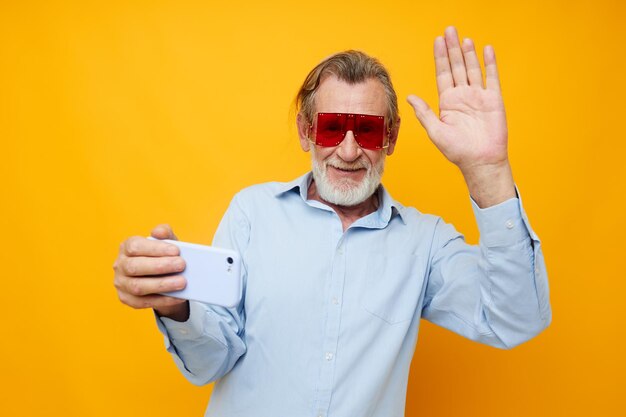 Senior hombre canoso camisas azules con gafas toma una vista recortada selfie