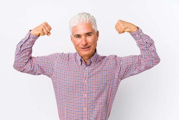 Foto senior hombre caucásico aislado mostrando gesto de fuerza con los brazos, símbolo del poder femenino