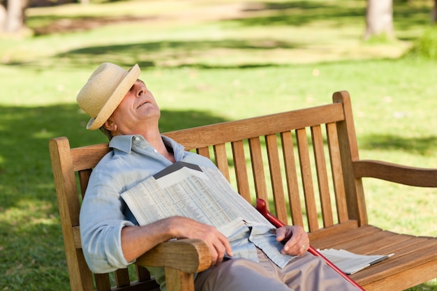 Foto senior hombre durmiendo en el banco