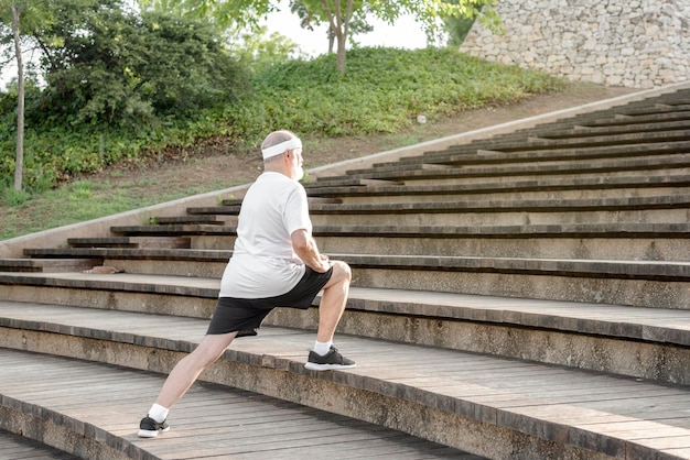 Senior hombre estirando en las escaleras al aire libre