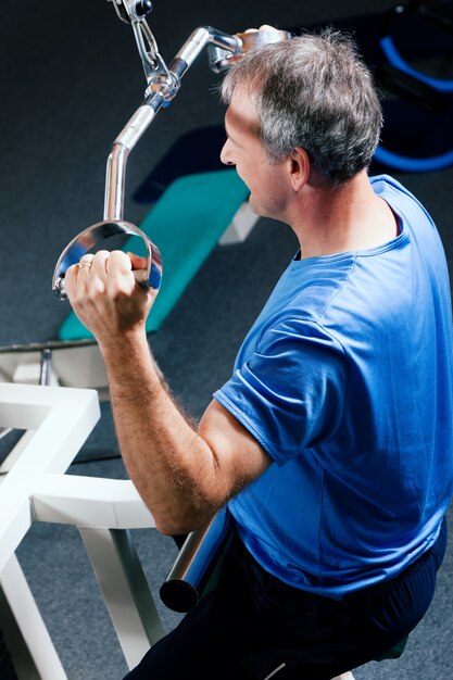 Senior hombre haciendo ejercicio en el gimnasio