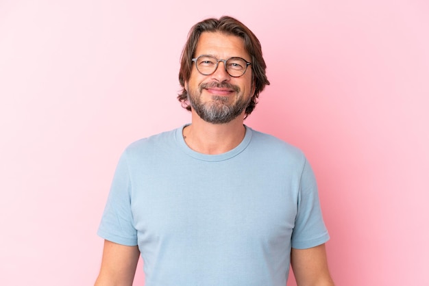 Senior hombre holandés aislado sobre fondo de color rosa con gafas con expresión feliz