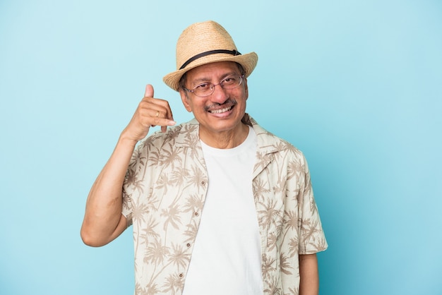 Senior hombre indio vistiendo ropa de verano aislado sobre fondo azul Senior mujer india vistiendo un traje africano aislado sobre fondo blanco mostrando un gesto de llamada de teléfono móvil con los dedos.