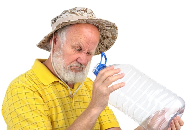 Senior hombre mirando la botella vacía