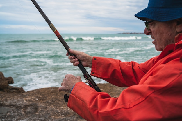 Senior hombre pescando en el mar.