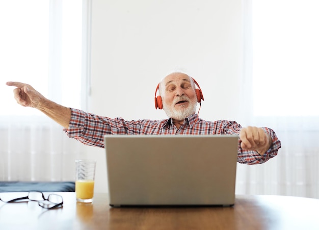 Senior hombre portátil música escuchando maduros ancianos auriculares auriculares tecnología doméstica