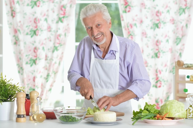 Senior hombre preparando la cena en la cocina