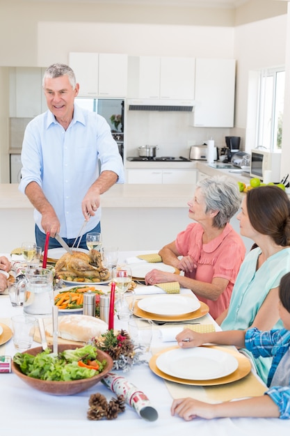 Senior hombre sirviendo comida a la familia