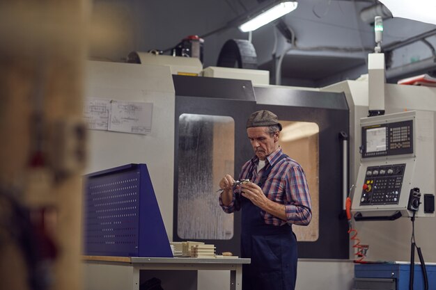 Senior hombre trabajando en el torno