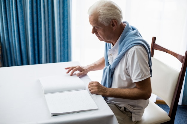 Senior hombre usando braille para leer