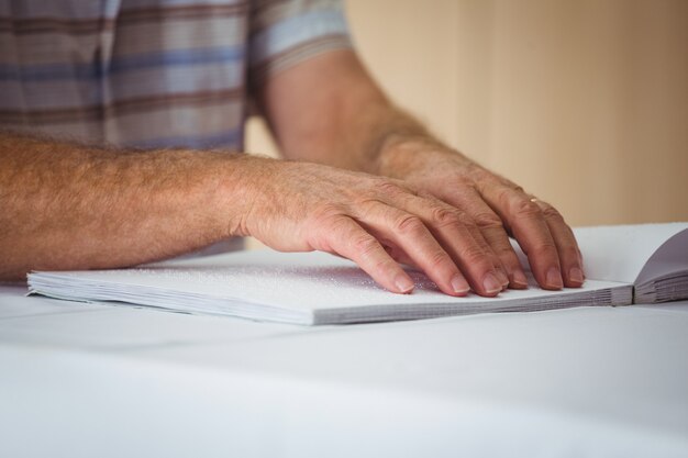 Senior hombre usando braille para leer