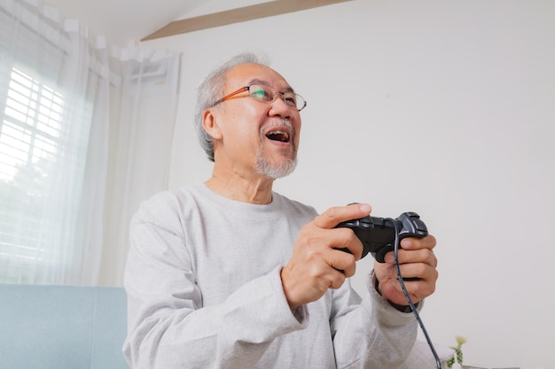 Senior hombre usando joystick senior sosteniendo joystick para jugar