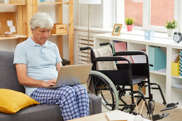 Senior hombre usando laptop