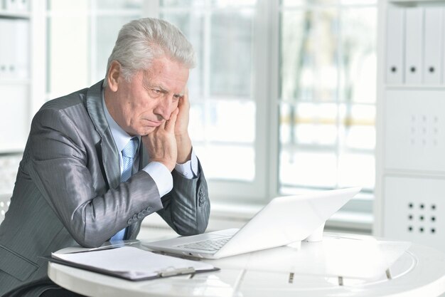 Senior hombre usando laptop