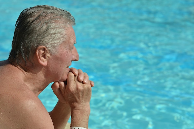 Senior Man sitzt in der Nähe des Swimmingpools