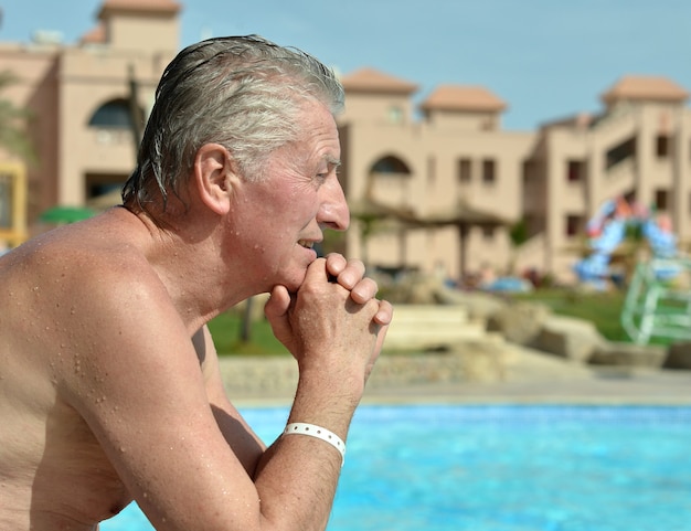 Senior Man sitzt in der Nähe des Swimmingpools