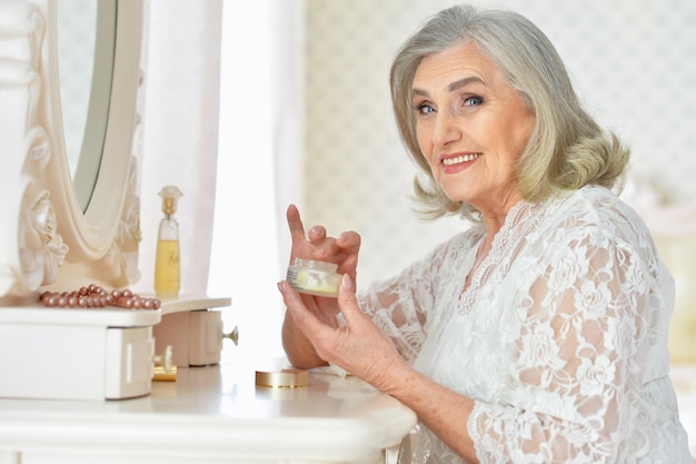Senior mujer aplicando crema
