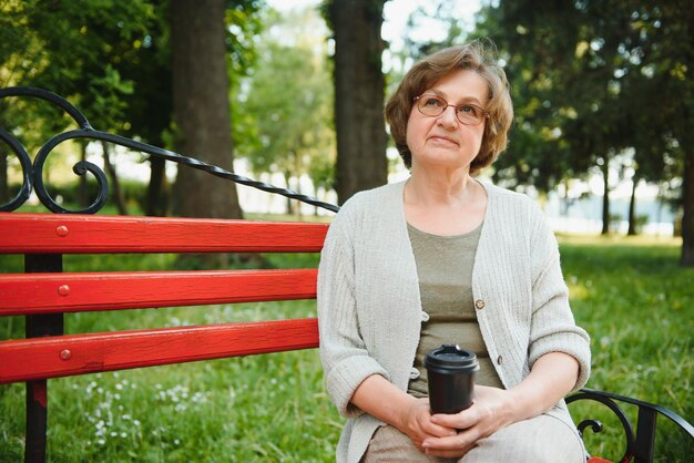 Senior mujer caminando en el parque en verano