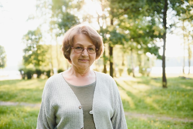 Senior mujer caminando en el parque en verano