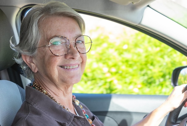 Senior mujer caucásica conduciendo el coche anciana disfrutando de conducir y viajar