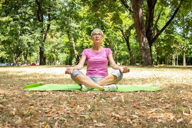 Senior mujer caucásica haciendo ejercicio de yoga y concentrándose en la respiración.