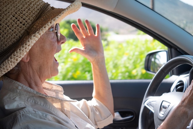 Senior mujer conduciendo coche conmocionado por accidente