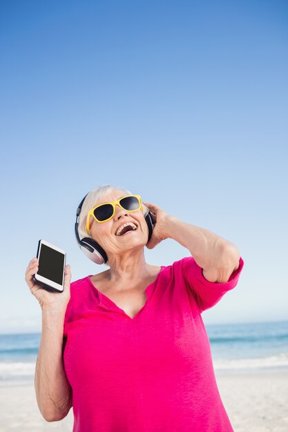 Senior mujer escuchando música con auriculares