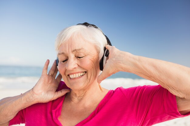 Senior mujer escuchando música con auriculares