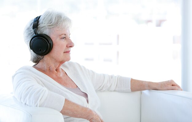 Senior mujer escuchando música con auriculares