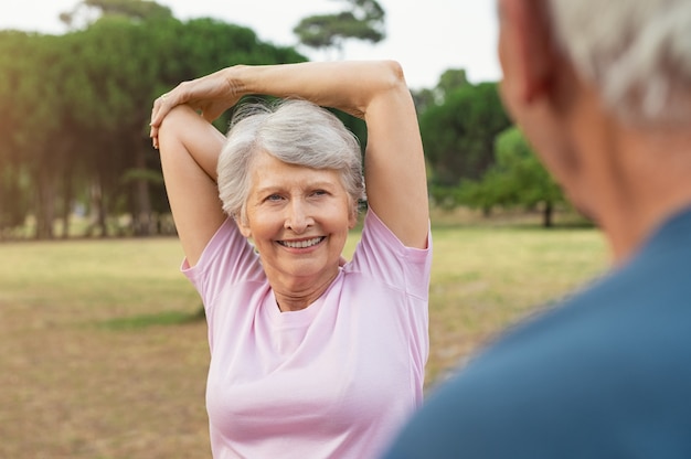 Senior mujer estirando los brazos