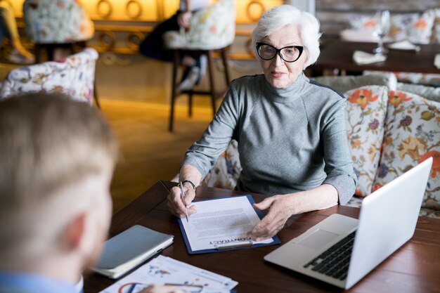 Senior mujer firmando un contrato