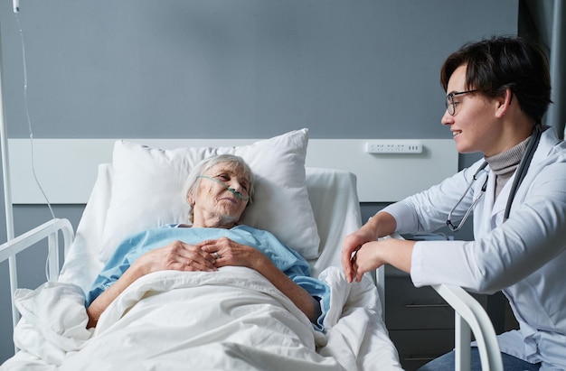 Senior mujer hablando con la enfermera en la sala