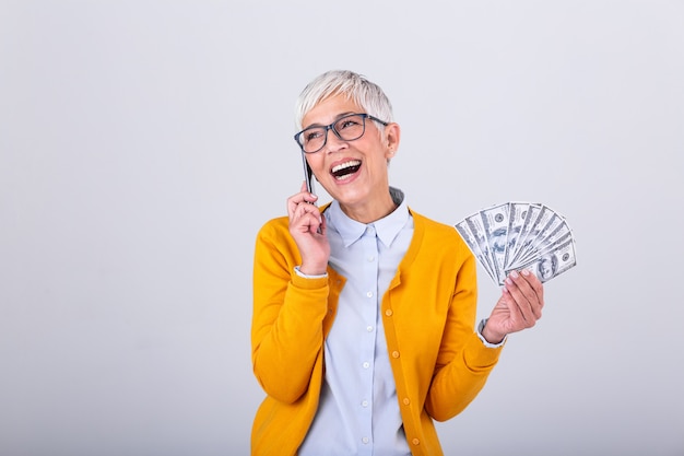 Senior mujer hablando por su teléfono inteligente y con dinero