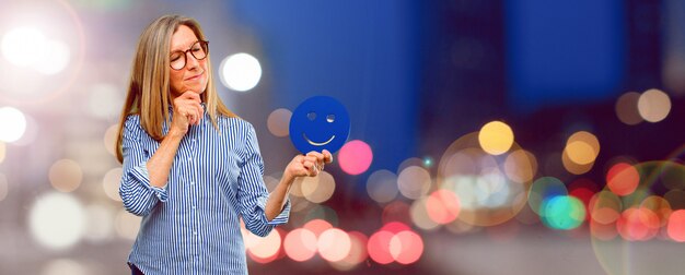 Senior mujer hermosa con un emoticon sonriente