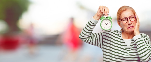 Foto senior mujer hermosa con un reloj de alarma