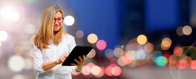 Senior mujer hermosa con una tableta de pantalla táctil