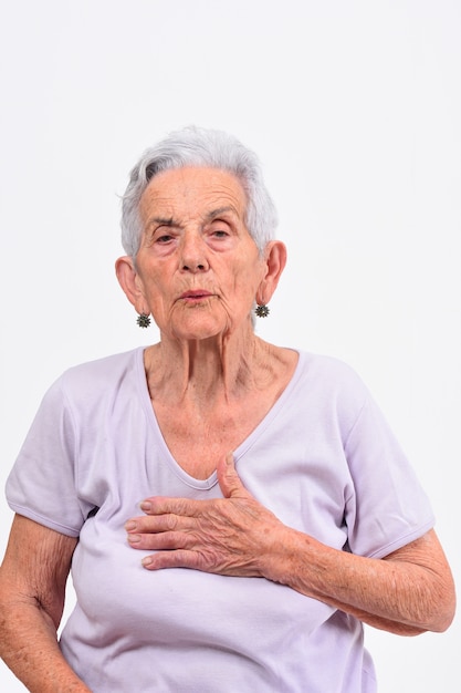 Senior mujer con la mano al corazón por un susto