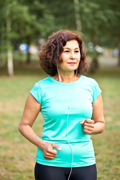 Senior mujer de mediana edad corriendo al aire libre en un parque