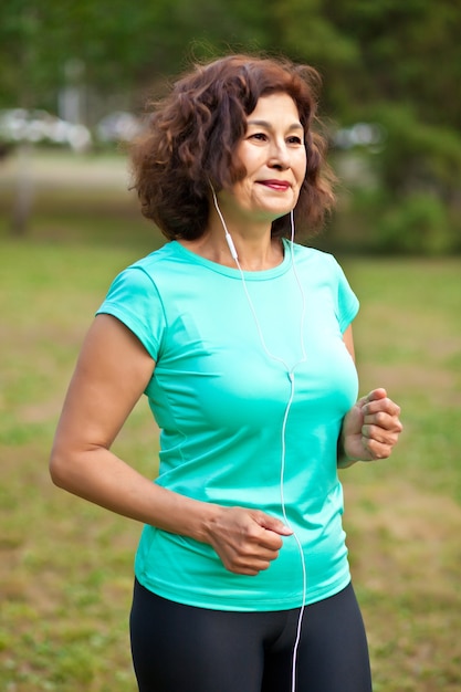 Senior mujer de mediana edad corriendo al aire libre en un parque