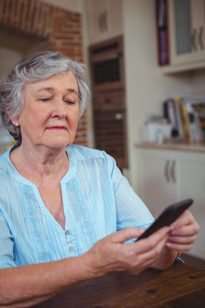 Senior mujer mensajes de texto en el teléfono